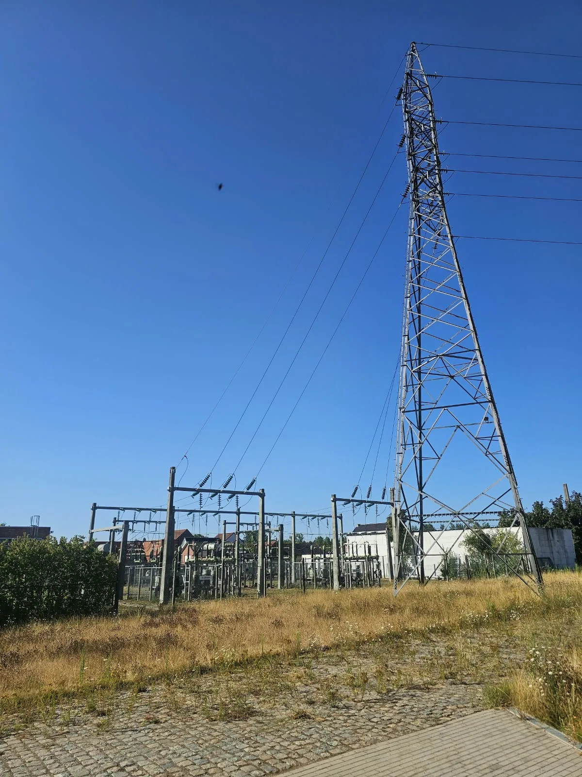 Hoogspanningsmast en bovengrondse aansluitingen bij een station