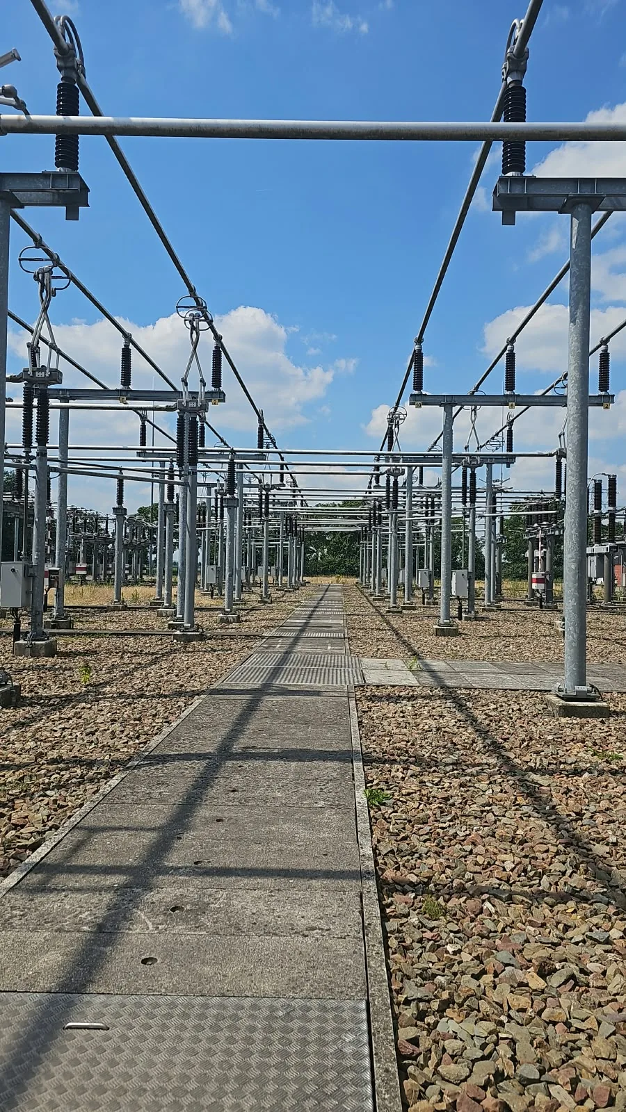 Hoogspanningsschakeltuin met railsystemen en een centraal toegangspad